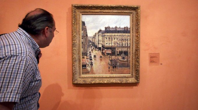 CORRECTS CAPTION THROUGHOUT TO REFLECT LATEST DEVELOPMENTS ON STORY - FILE- In This May 12, 2005 File Photo An Unidentified Visitor Looks At The Impressionist Painting Called "Rue St.-Honore, Apres-Midi, Effet De Pluie" Painted In 1897 By Camille Pissarro, On Display In The Thyssen-Bornemisza Museum In Madrid. A Federal Judge In California Has Dealt A Blow To A Jewish Family's Prolonged Battle To Regain Ownership Of The Masterpiece Seized From A Woman Fleeing Nazi Germany In 1939 And Now On Display In The Museum In Spain. Judge John Walter Found That Under Spanish Law, The Thyssen-Bornemisza Museum In Madrid Is The Rightful Owner Of "Rue Saint-Honore, Apres-midi, Effet De Pluie." In Last Week's Ruling, Walter Dismissed A 2005 Lawsuit Filed By The Woman's Heirs Against The Museum, But Urged The Institution To Consider What Would Be Fair To Victims Of Nazi Persecution. (AP Photo/ Mariana Eliano, File)