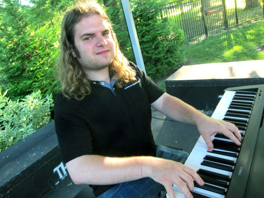 Luke Sailor sitting at a keyboard, hands poised to play.